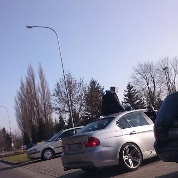 Idiota je�dzi� na dachu BMW i macha� do ludzi